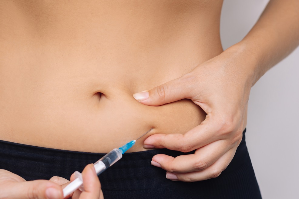 Woman receiving an injection in her abdomen.