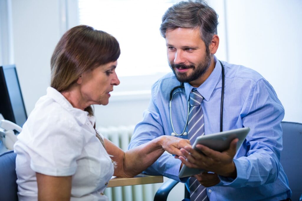 Doctor and patient reviewing tablet.