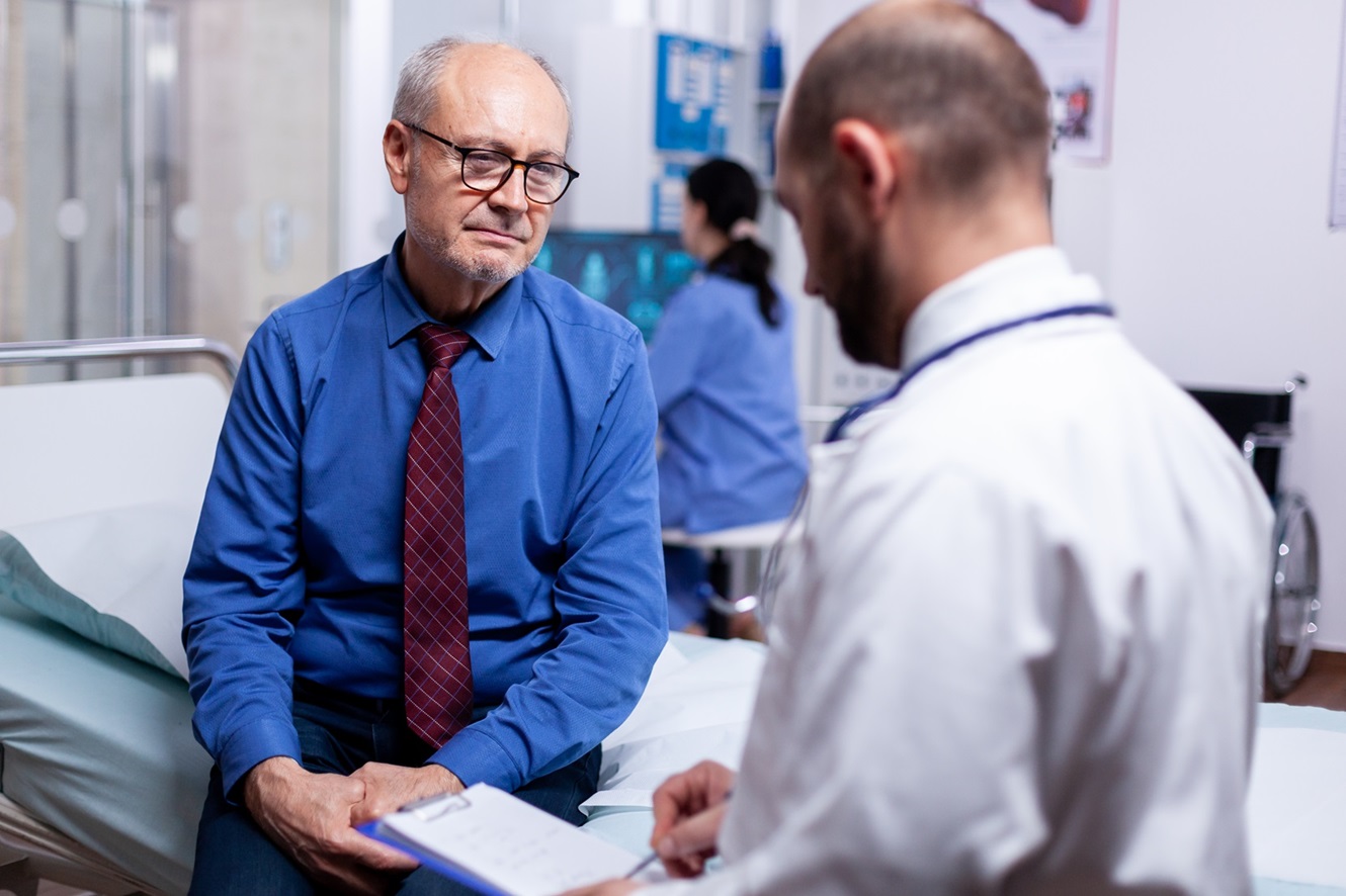 Doctor consulting senior patient in hospital.